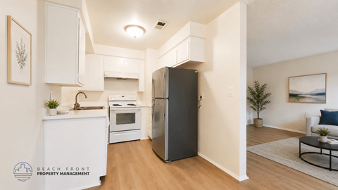 A modern kitchen with a refrigerator, sink, and cabinets.