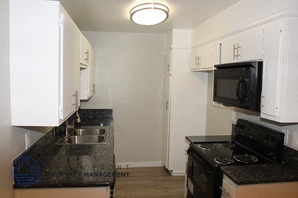 a kitchen with a stove and a sink and a microwave