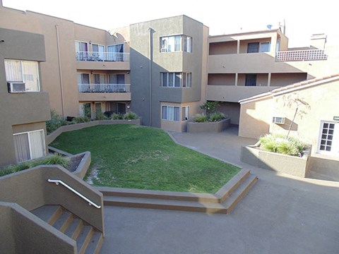 Apartment complex with a green lawn in the courtyard.