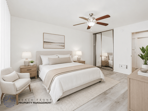 A well-lit bedroom with a large bed, a chair, and a ceiling fan.