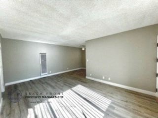 an empty living room with gray walls and wood floors