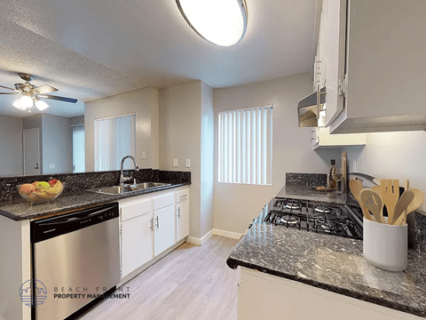 A kitchen with a black stove top oven and white cabinets.