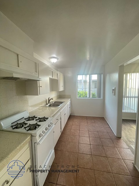 A kitchen with a stove top oven and a sink.