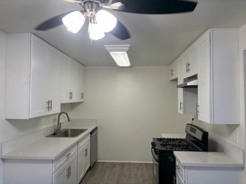 A kitchen with white cabinets and a black stove top oven.
