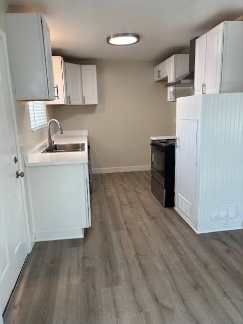 A kitchen with white cabinets and a black oven.