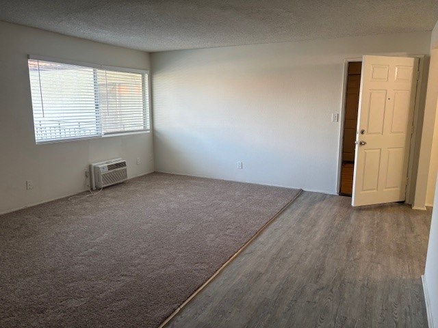 A room with a carpeted floor and a window with blinds.