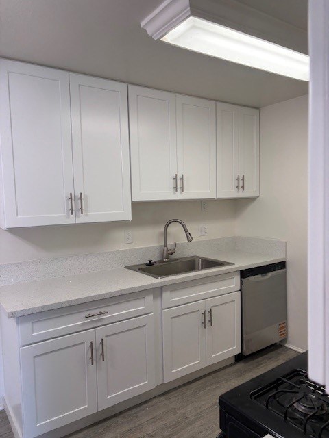 A kitchen with white cabinets and a black stove.