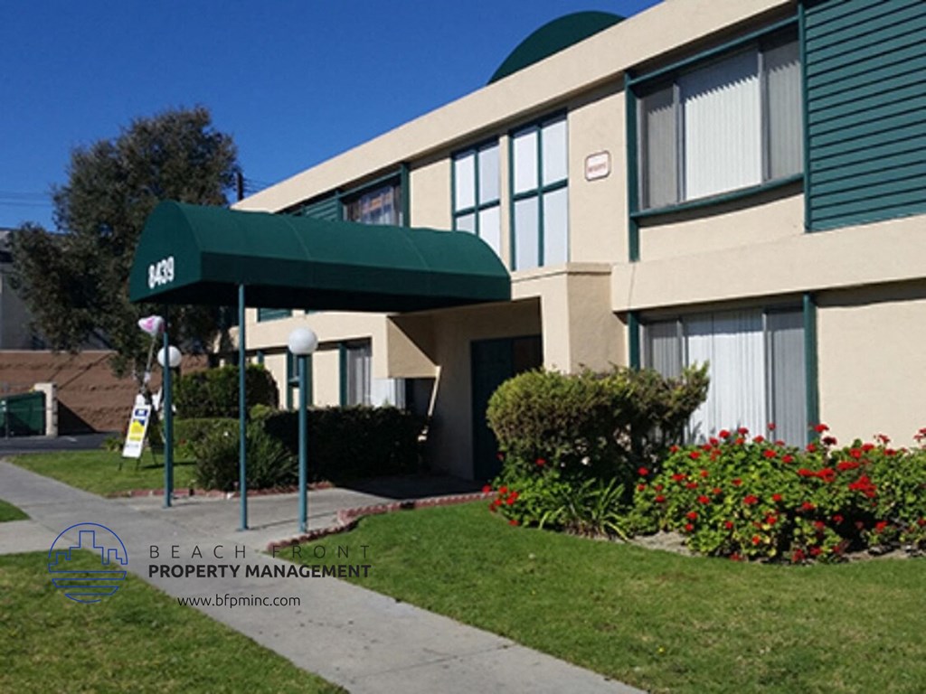 a building with a green awning in front of a sidewalk