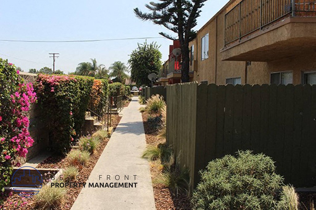 a sidewalk next to a fence and a building