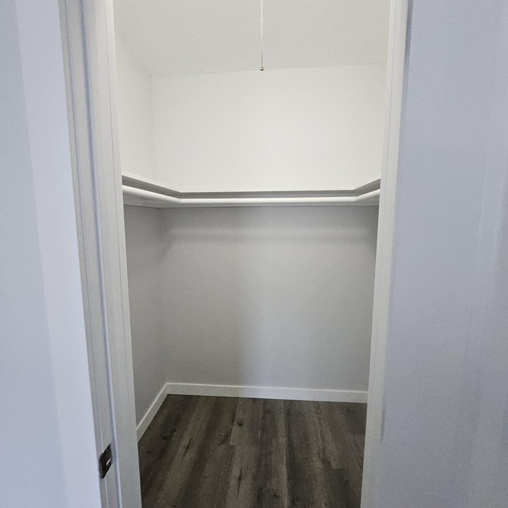 a room with white walls and a white ceiling and wood floors