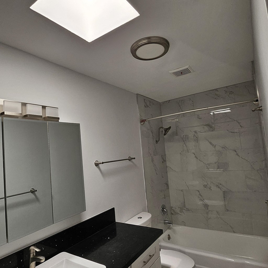 a bathroom with a shower and a sink and a toilet