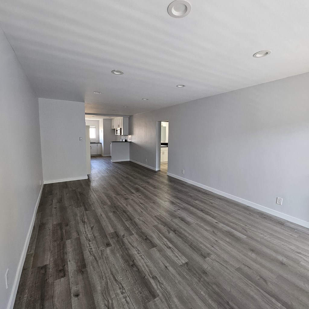 a living room with white walls and wooden floors