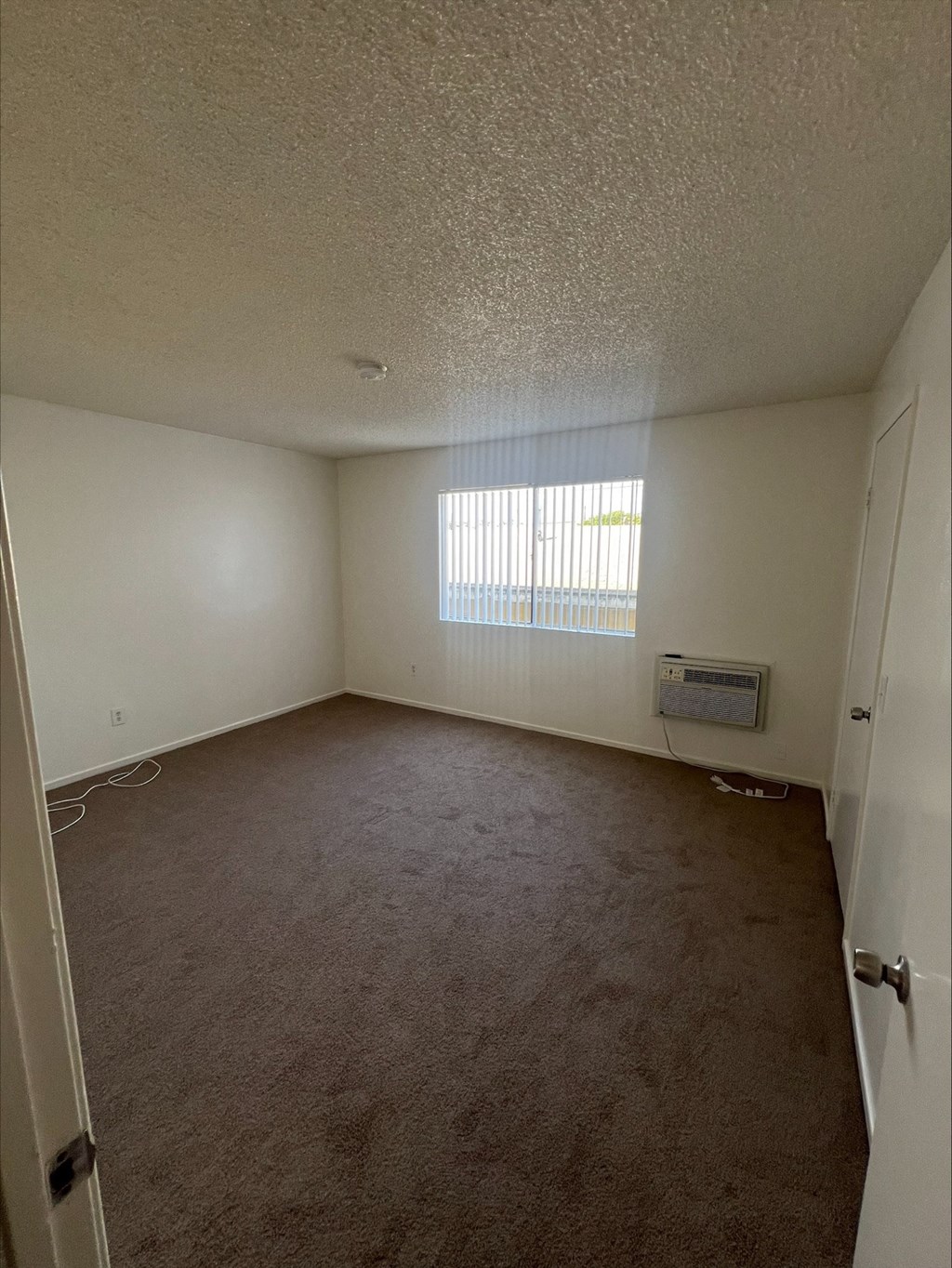 an empty living room with a window and a door