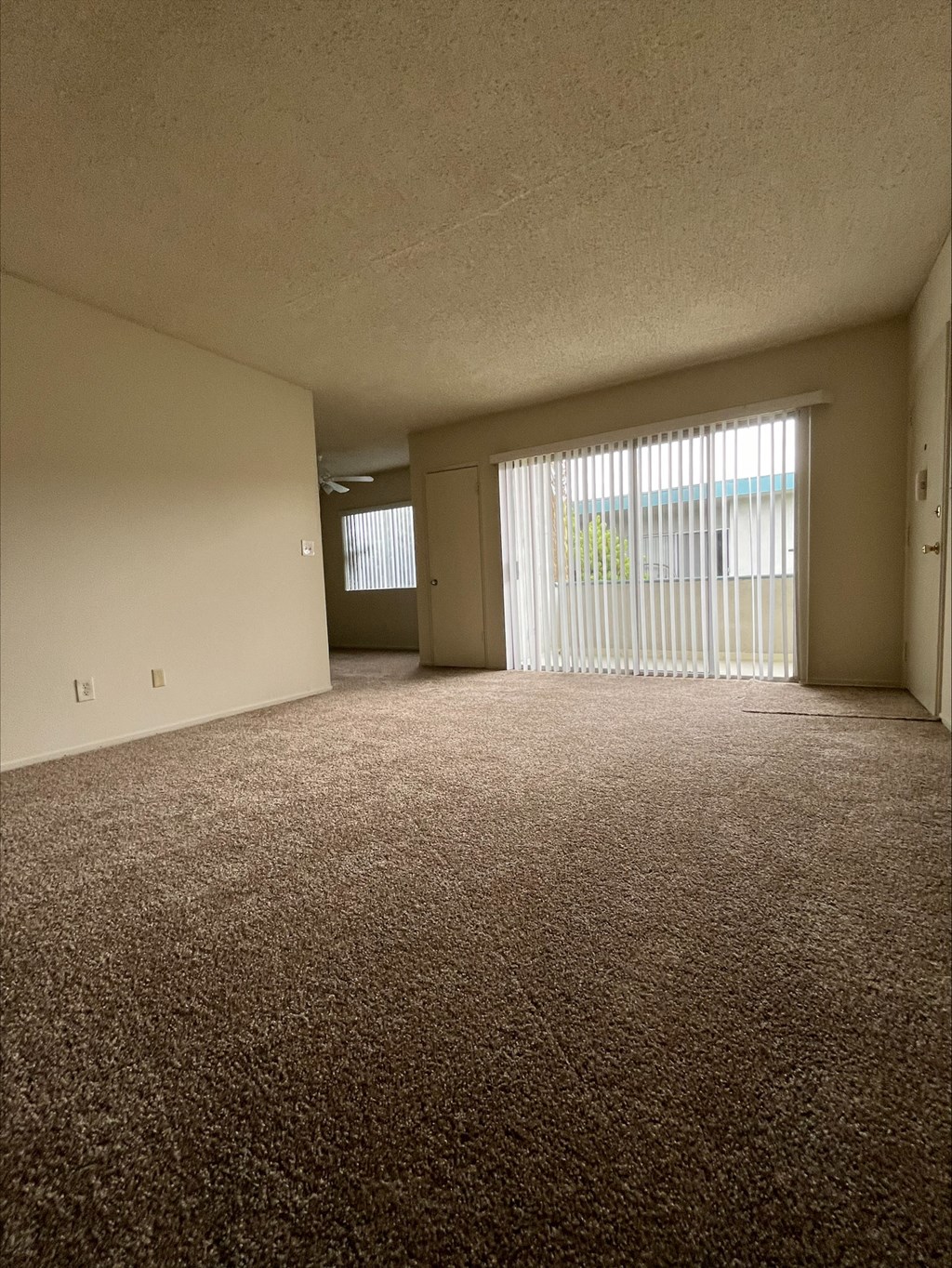 an empty living room with a sliding glass door