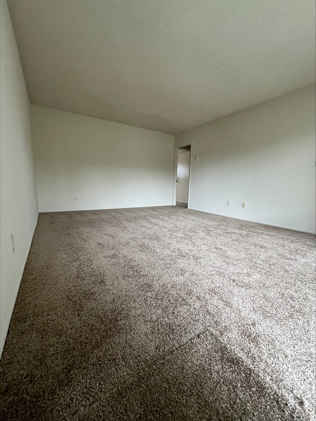 an empty room with carpet and white walls