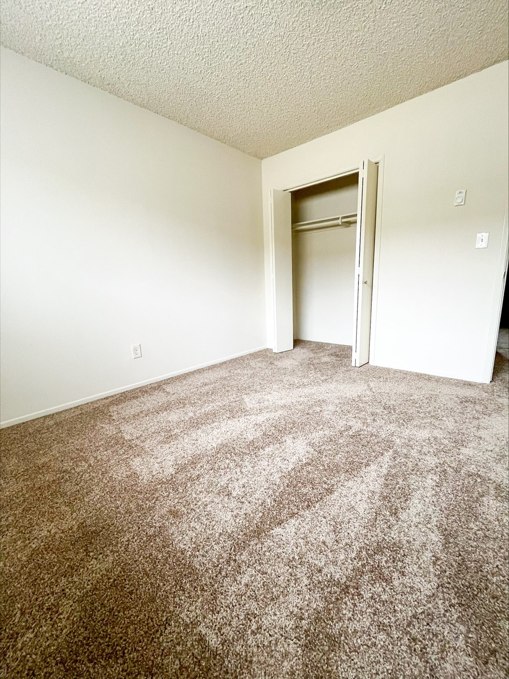 an empty living room with a door to a closet