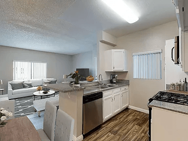 A kitchen with a stove top oven and a dining table.