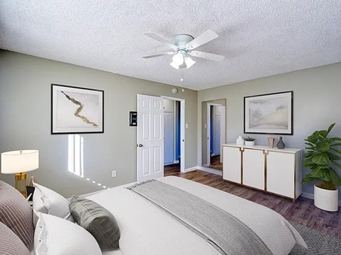 A bedroom with a large bed and a ceiling fan.