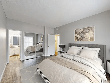 A bedroom with a large bed and a painting on the wall.