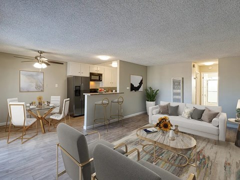 A living room with a grey couch, a coffee table, and a dining table with chairs.