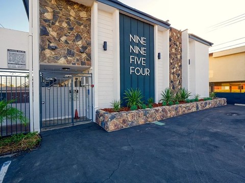 A building with a stone wall and a sign that reads "NINE FIVE FOUR".