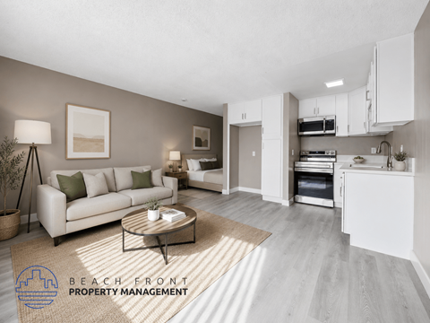 A modern living room with a coffee table and a kitchen area in the background.