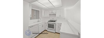 A kitchen with white appliances and cabinets.