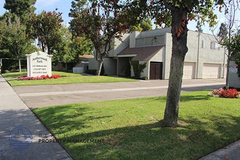 a building with a sign in front of it and a tree