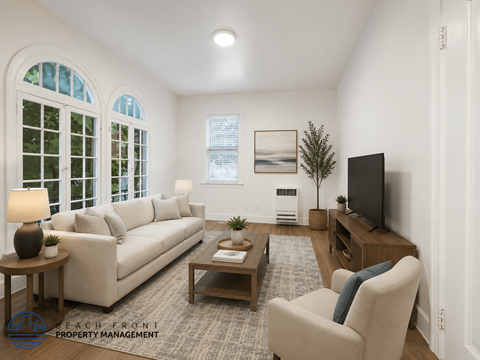 A living room with a couch, chair, and television.