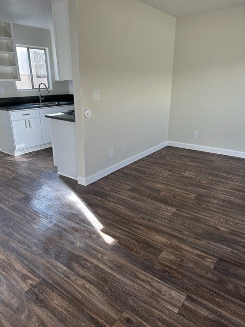 an empty kitchen and living room with wood flooring