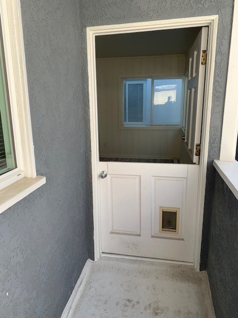 A white door with a window above it in a room.