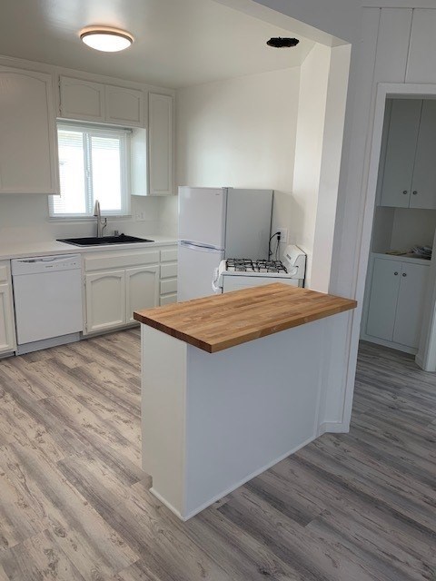 A kitchen with a white fridge and a wooden counter.