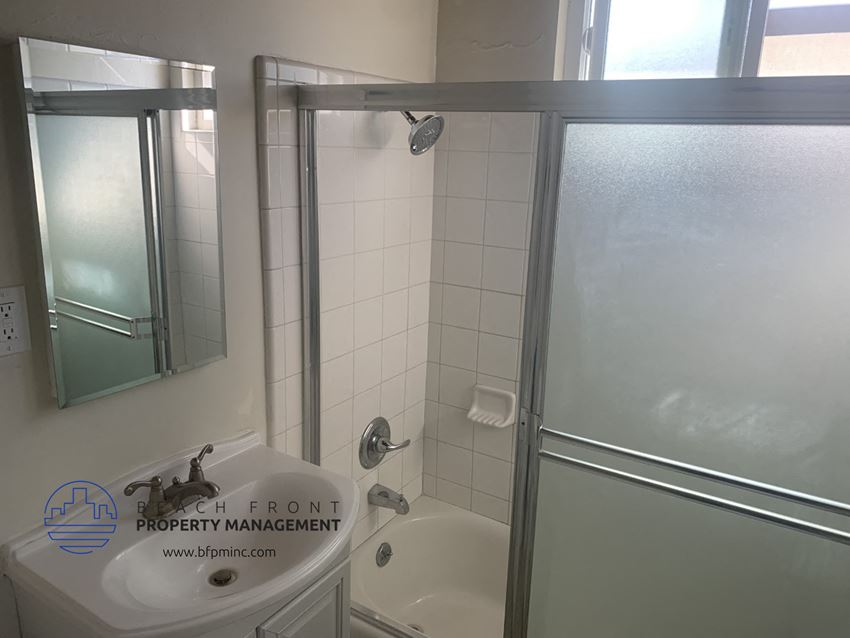 a bathroom with a shower and a sink and a mirror