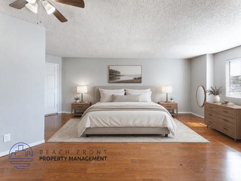 A bedroom with a large bed, two nightstands, and a ceiling fan.