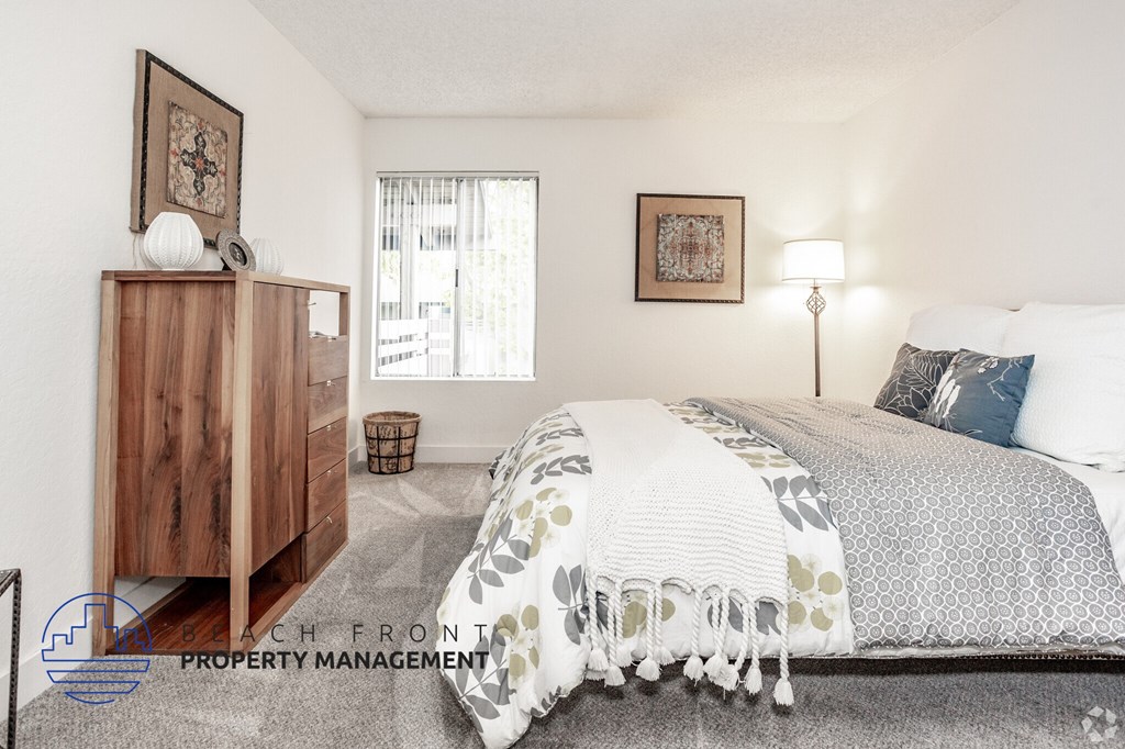 A bedroom with a bed, nightstand, and a wooden dresser.