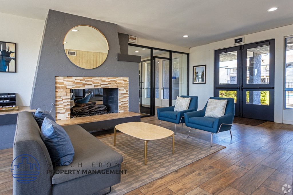 A modern living room with a fireplace and blue chairs.
