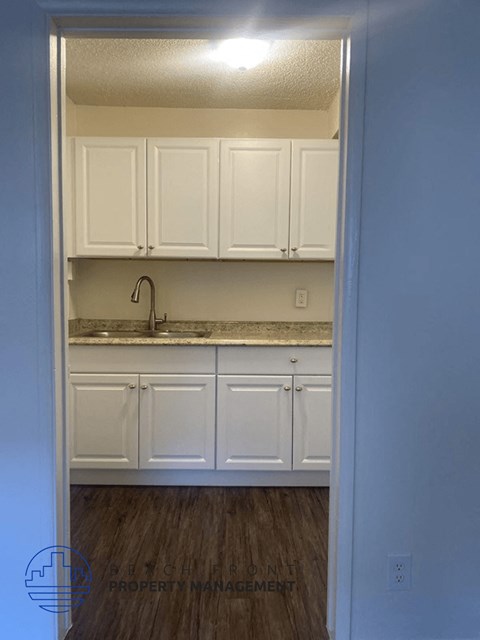 A kitchen with white cabinets and a sink.