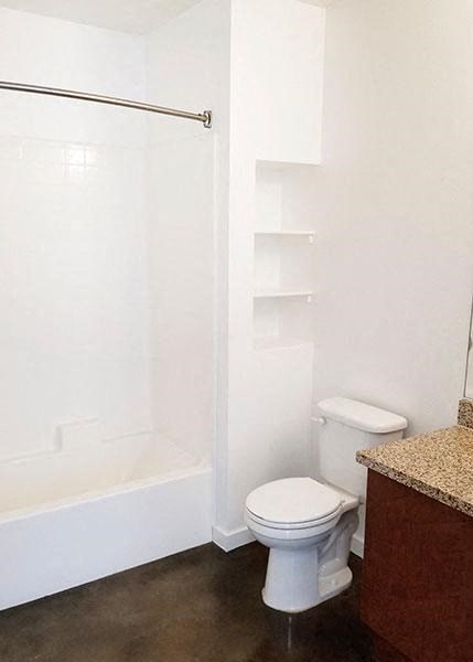 a bathroom with a white toilet and a shower