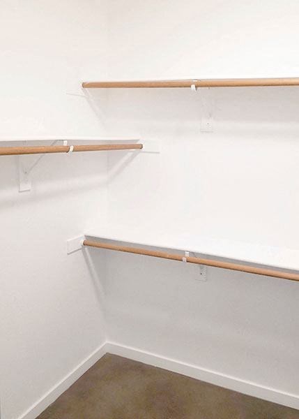 a walk in closet with empty shelves on the wall
