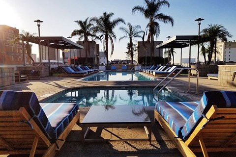 a swimming pool with chairs and a table