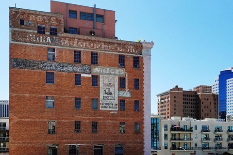 a red brick building with an old advertisement on the side of it
