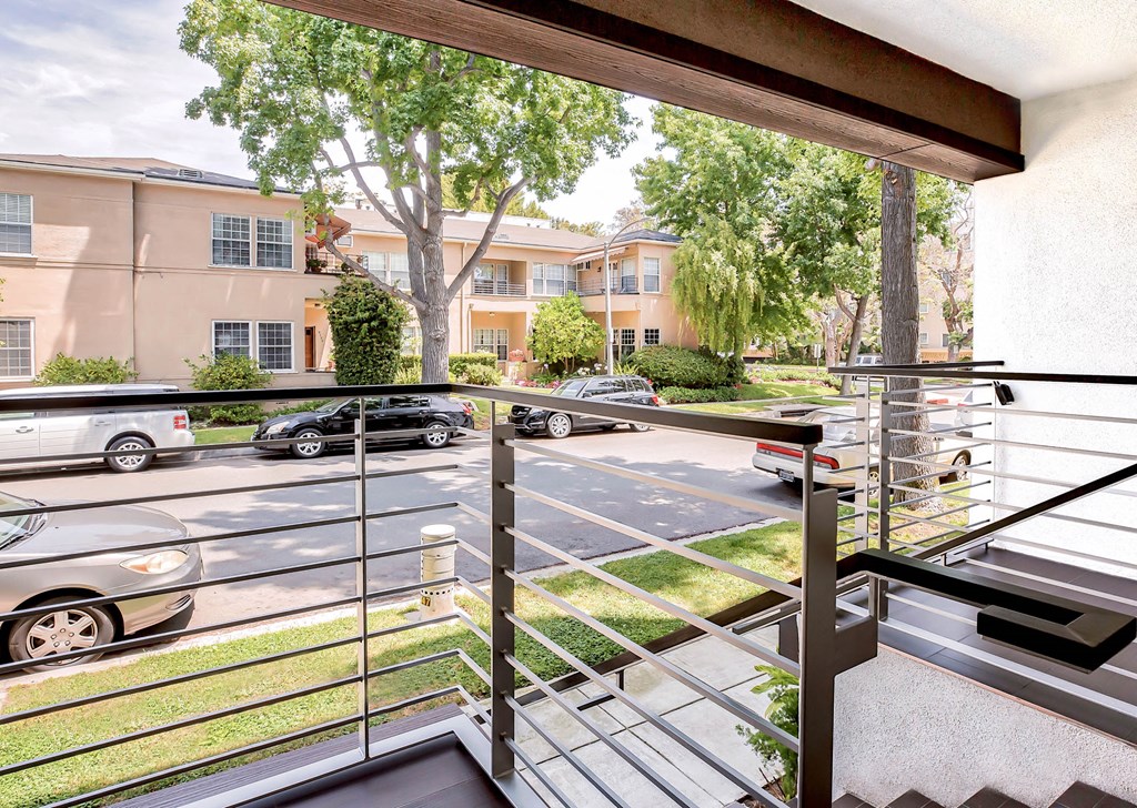 a balcony with cars parked in a parking lot