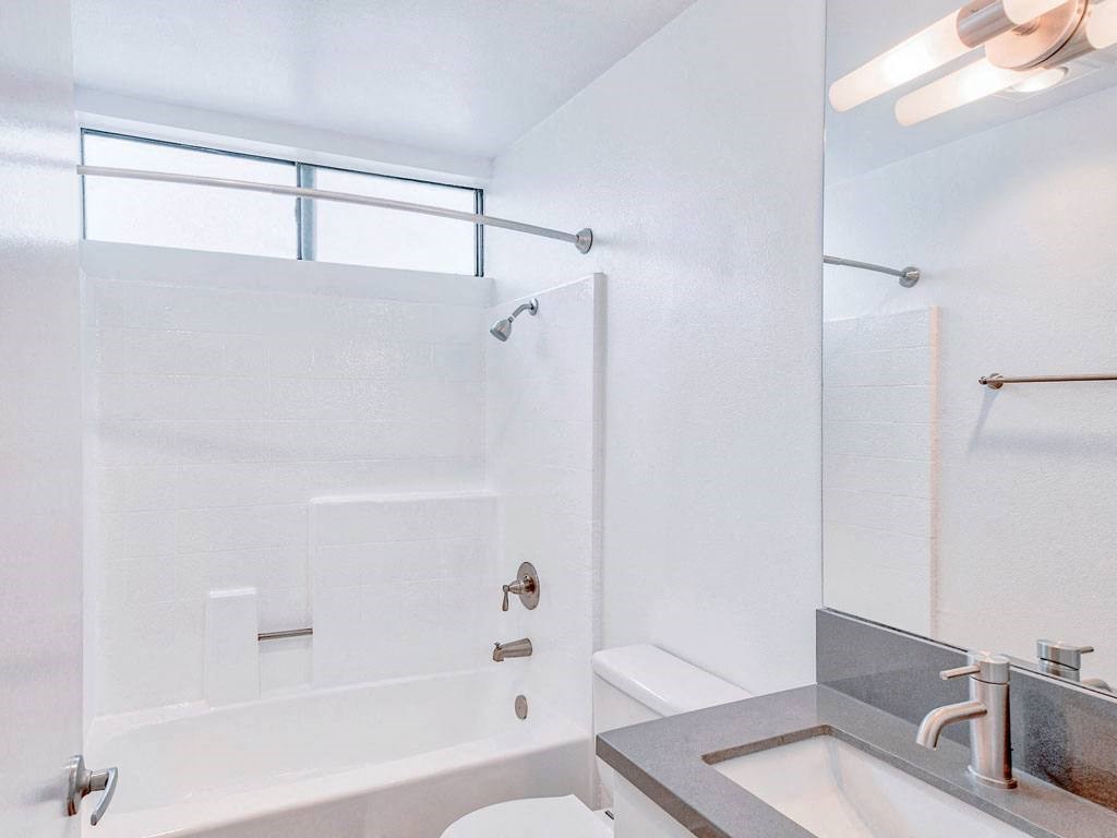 a bathroom with a shower and a sink and a toilet