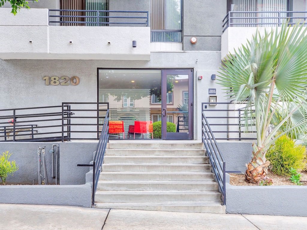 the front entrance of a building with stairs and a glass door