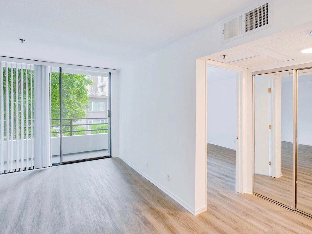 an empty living room with sliding glass doors to a balcony