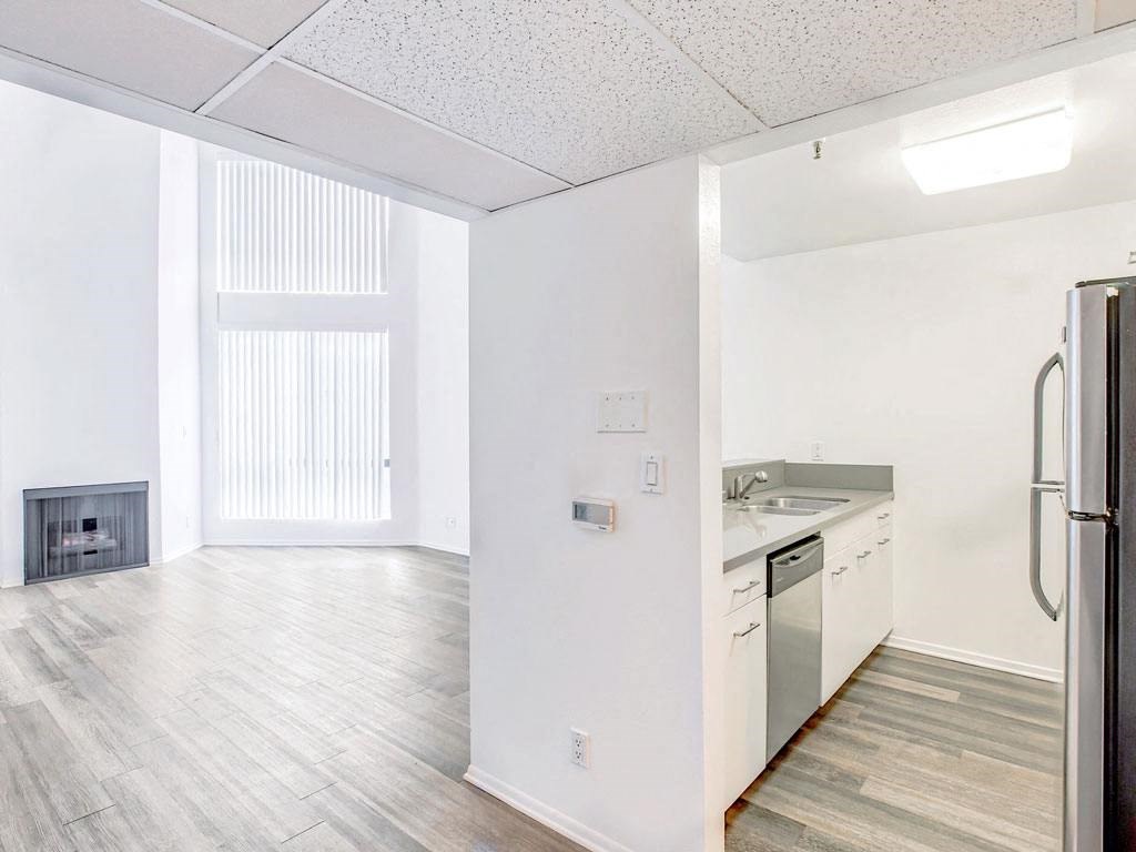 an empty kitchen and living room with a stove and refrigerator