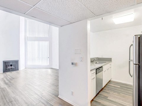 an empty kitchen and living room with a stove and refrigerator