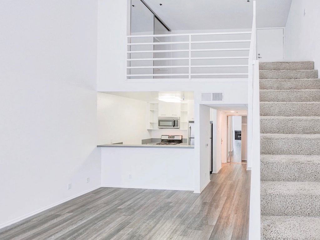 a white house with a staircase and a kitchen