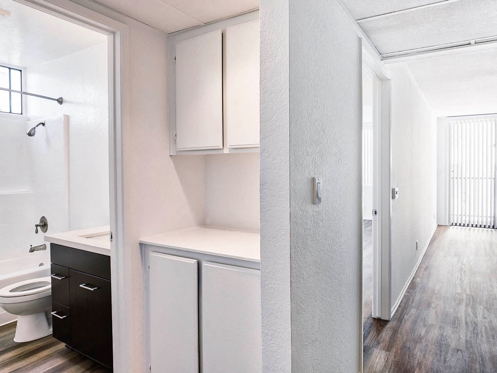 an empty bathroom with white cabinets and a toilet