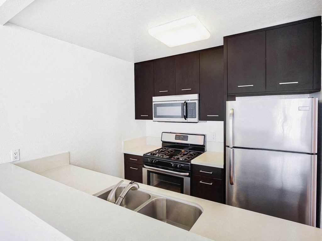 a kitchen with stainless steel appliances and black cabinets